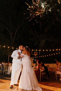 bride and groom dancing at night under twinkle lights