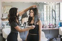 Hair stylist branding shoot photo where hair stylist is hair spraying a models hair.