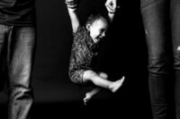 Luxury Portraits by Moving Mountains Photography in NC - Black and white photo of a baby swinging from his parents arms.