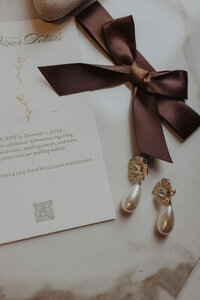 Wedding Detail Photo with Invitation Earrings and Bow
