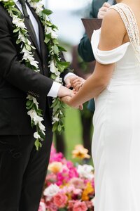 A close up of a wedding couple holding hands during their ceremony  