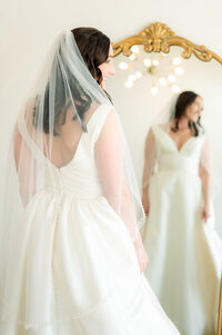 bride faces a mirror while looking to the side