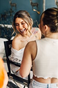 Bride smiling while having makeup done for wedding day