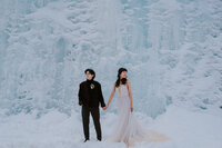 A same-sex couple eloping in front of a frozen waterfall in Kananaskis