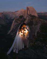 couple walking along beach with lanterns