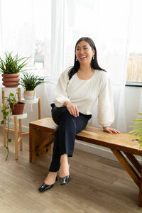 woman sitting on bench leaning and smiling off camera