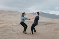 couple dances on sand dunes