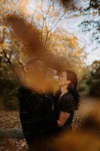 couple hugging under falling leaves