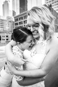 Same sex brides embracing outside the alleyway of Loring Social Minneapolis wedding photography
