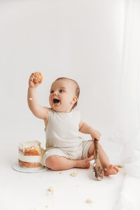 cake smash photography session in phoenix baby eating white cake