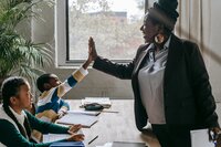 Woman giving high five to young man sitting next to young girl.