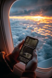 Mobile view of Old Fangled GB website displayed on a plane, with sunset in background