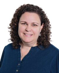 woman with curly brown hair and wearing a blue shirt