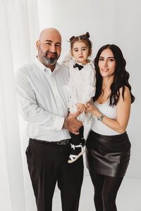 family of 3 posing for classic studio family session in phoenix