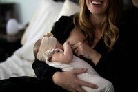 A woman holds and breastfeeds her baby.