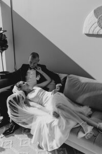bride and groom embrace on couch at wedding venue in san diego
