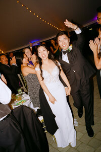Black and white 35mm film portrait of a bride in a beaded cape sitting by the window at Linden Place in Newport, RI — captured by a film wedding photographer.