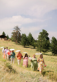 Colorado outdoor summer mountain wedding in Boulder with parasols and mismatched bridesmaids dressed.
