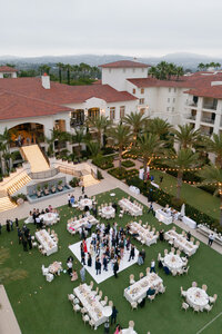 Couple shares a kiss during their wedding portraits, with the bride's veil blowing in the wind among the high grasses along the East Coast shoreline.