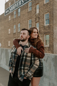 A person standing behind their partner with their arms around their shoulders