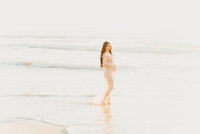 Family Photographer, two girls hold hands on the beach