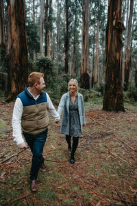 engaged couple walking together in the dandenong forest in winter