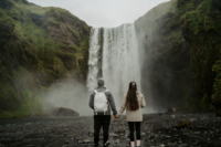 couple standing near waterfall