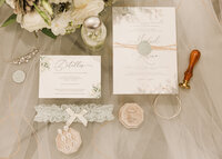 Wedding Details of invites, rings, and garter taken in Santa Ana California