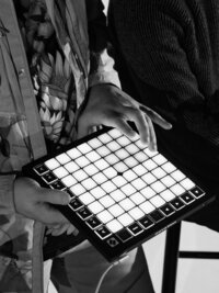 Hands hovering over an illuminated launchpad controller – bold music branding photo showing behind-the-scenes action by Mewphotovideo