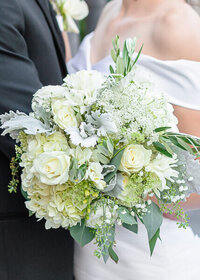 A close-up of a bouquet with while roses and greenery at Sleepy Ridge Weddings