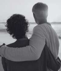Couple watching the waves on the beach while hugging representing the happiness you can experience after participating in betrayal trauma recovery program with Relationship Experts based in Florida, US