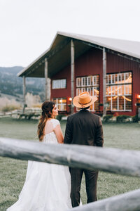 bride and groom holding hands near ranch