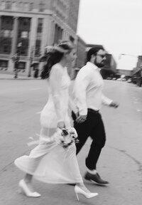 bride and groom walking across street in vermont