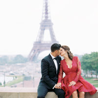 Couple all dressed up and kissing during anniversary photo session in front of Eiffel Tower