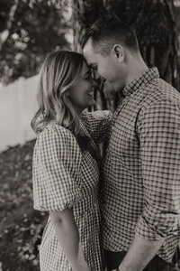 A couple with their heads together smiling and posing for a photo