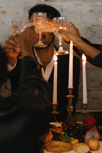 Documentary wedding photographer in Birmingham AL documents an intimate candlelit dinner with guests clinking glasses