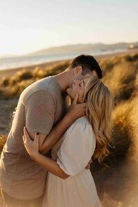 a golden hour in a outdoor area and the guy is kissing her partner