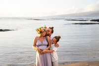 Mom holding daughter on the beach during golden hour for a big island Hawaii photography session