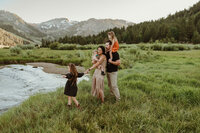 Mom in a white dress holding her  baby boy in the middle of beautiful plants at the