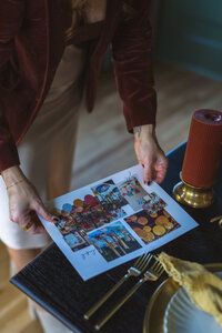 An event planner in Northwest Arkansas reviews visual materials at a dining table set for luxury event planning.