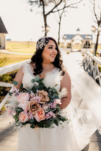 The bride poses at a Willow Creek Wedding Venue in Waxahachie, showing off her bouquet.