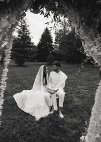 Bride and groom under floral arch Orange County photographer moment