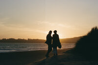 photo of bride and groom walking down the beach at sunset taken by San Francisco wedding photographer