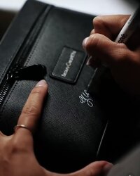 Professional calligraphy on a black leather cosmetic bag