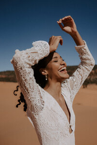 bride laughing with hands in the air