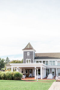 The elegant exterior of Wychmere Beach Club in Harwich Port, MA, featuring its iconic tower and waterfront lawn. A timeless Cape Cod wedding venue with coastal charm and ocean views.