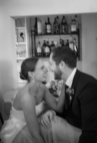 Black-and-white indoor portrait of a bride and groom smiling and leaning in together during their wedding at Ashlar Ottawa.
