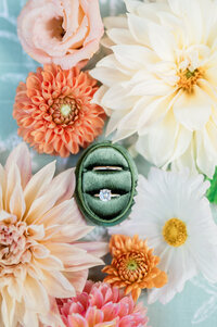 A ring box with colorful flowers all around it