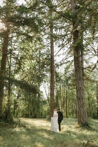 Film photo of bride and groom walking hand in hand at outdoor wedding venue by elopement photographer washington state
