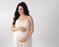 pregnant mom holding belly for studio portrait